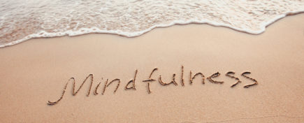 mindfulness concept, mindful living, text written on the sand of beach