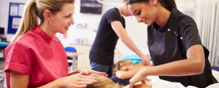 Teacher Helping Student Training To Become Masseuse